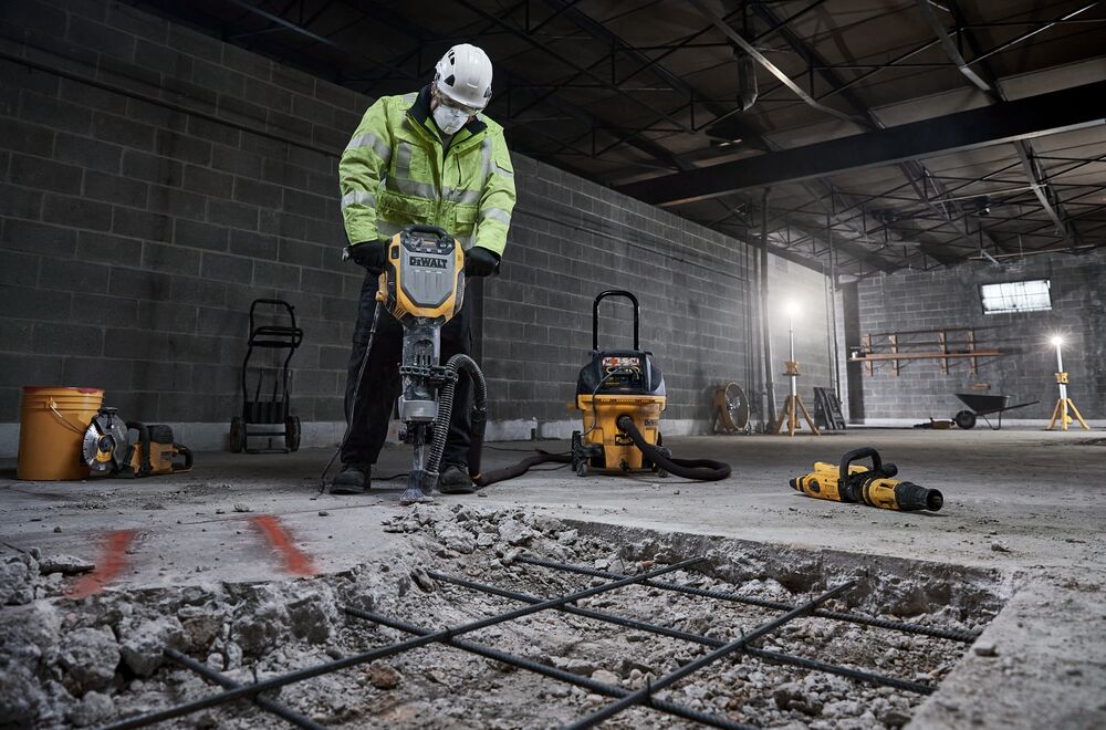 Demolition hammer with M Class dust extractor breaking up concrete  floor