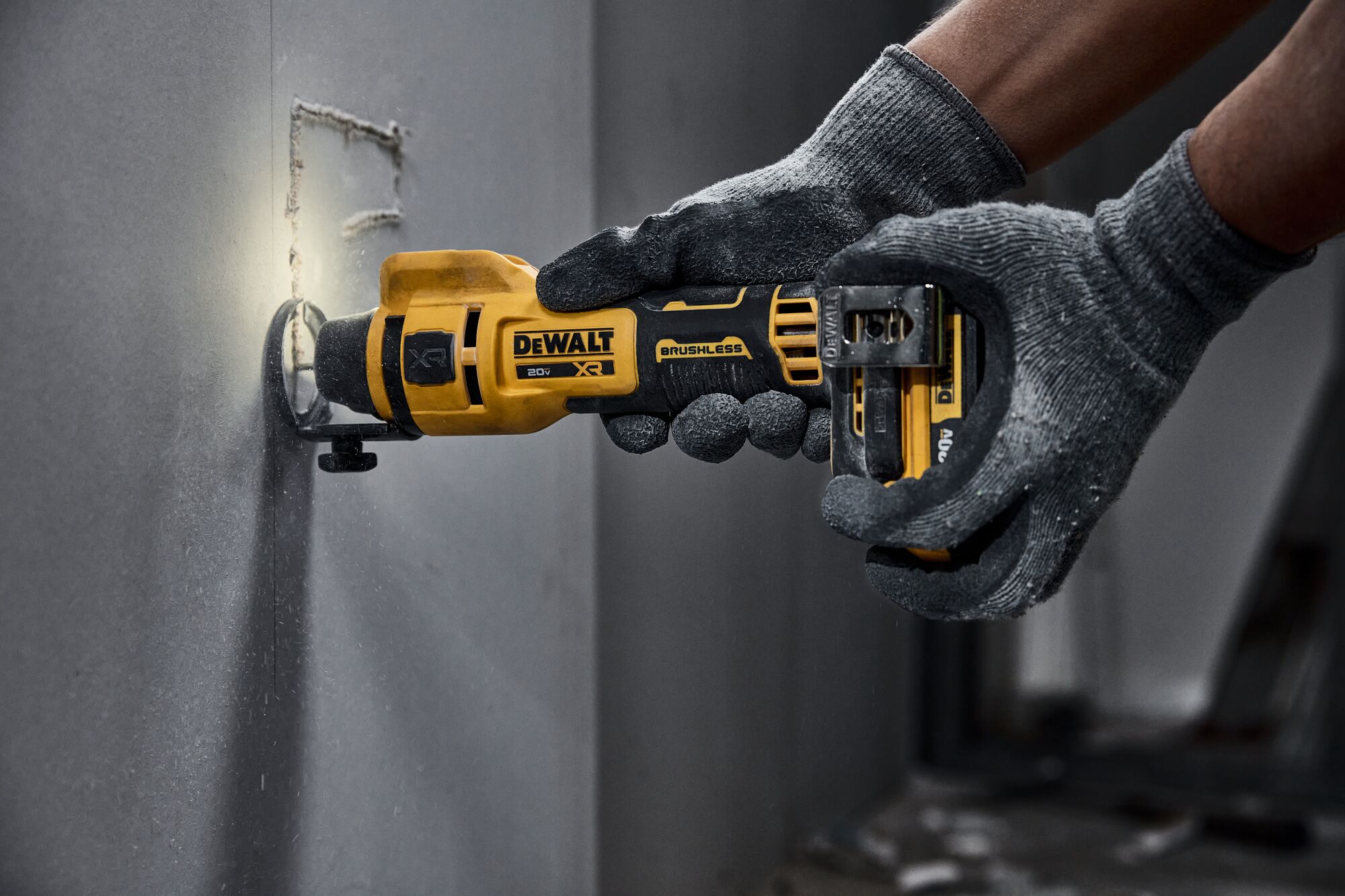 individual using a 20V MAX XR(®) Brushless Drywall Cutout Tool on a wall