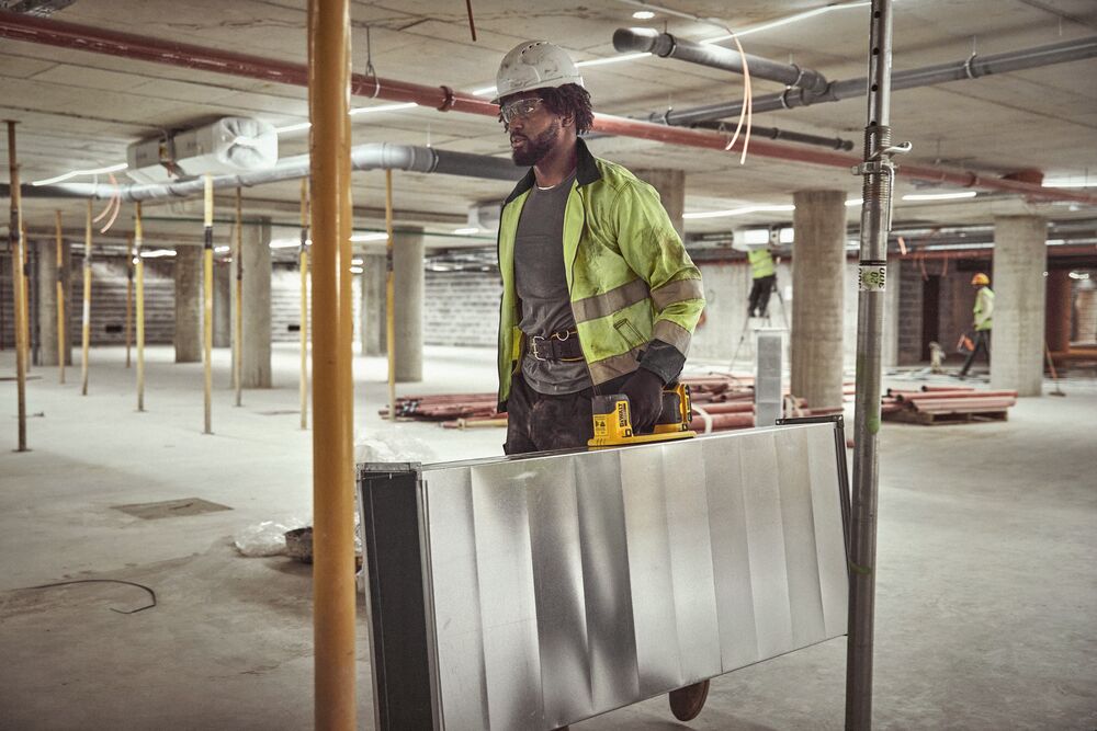 User lifting HVAC duck with DEWALT 20V MAX Grabo Lifter