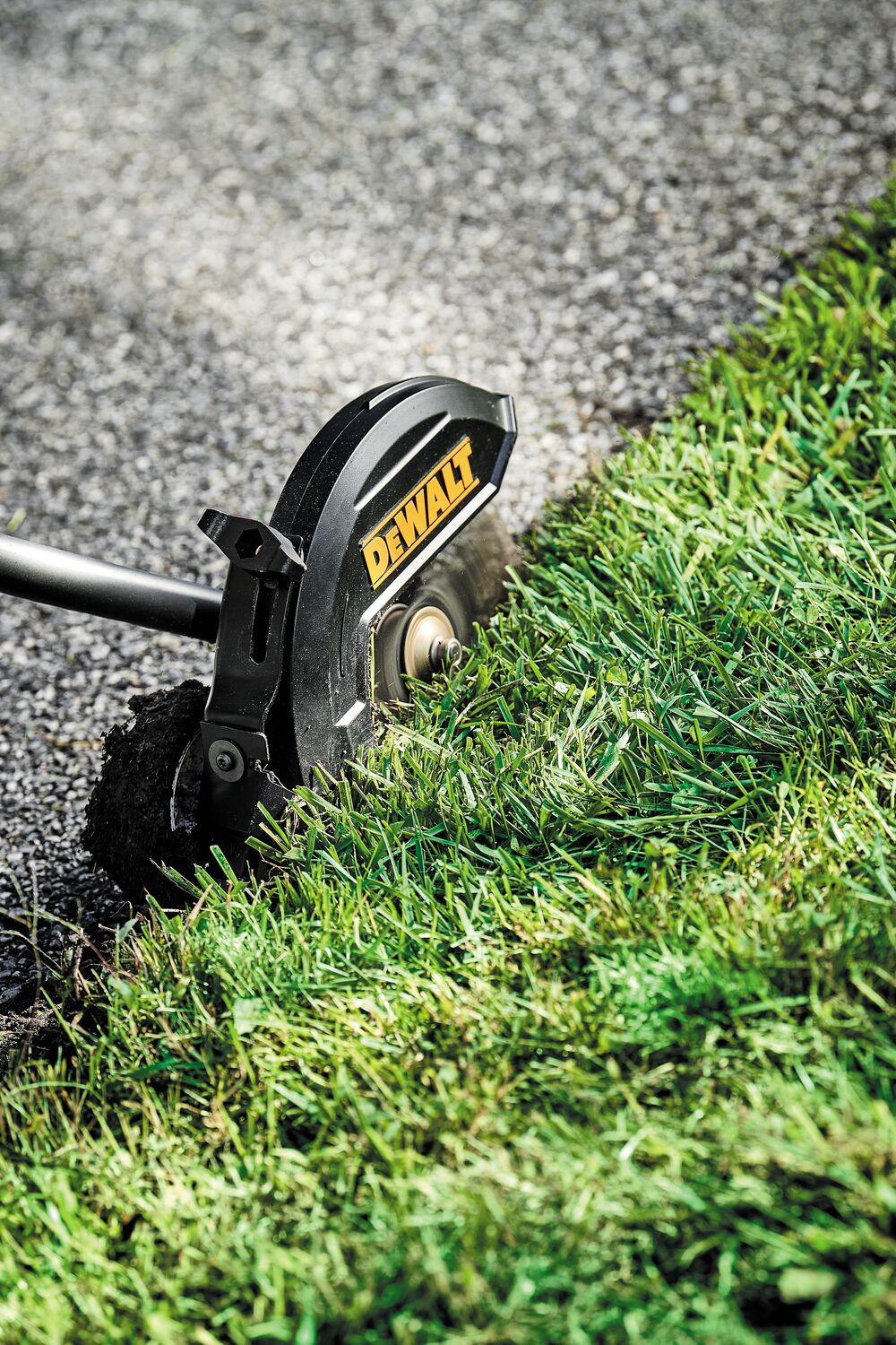 Close-up of brushless attachment capable edger kit cutting grass overgrowth.