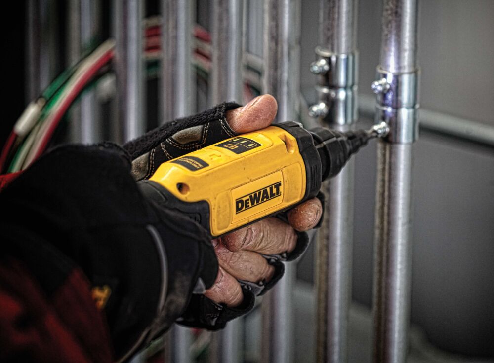Close-up of gyroscopic screwdriver with conduit reamer being used by person on electrical piping.