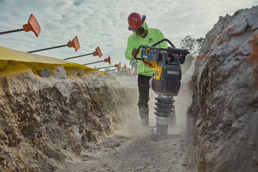DEWALT POWERSHIFT™ rammer compacting sand in trench