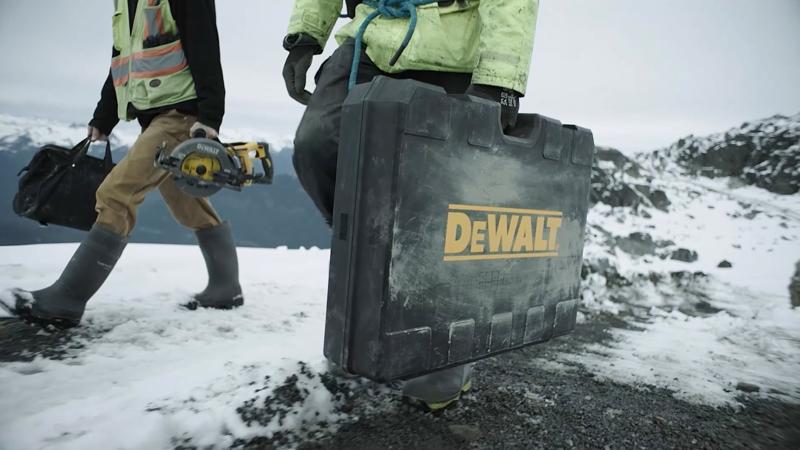 image of two men on a construction site carrying DEWALT storage and tools ready for the job