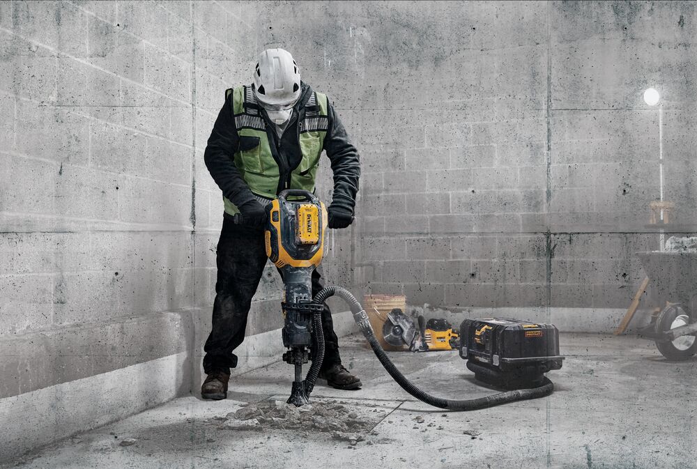 Man using 60 volt Max 38 pounds. 1-1/8 inch Hex Demolition hammer on concrete slab