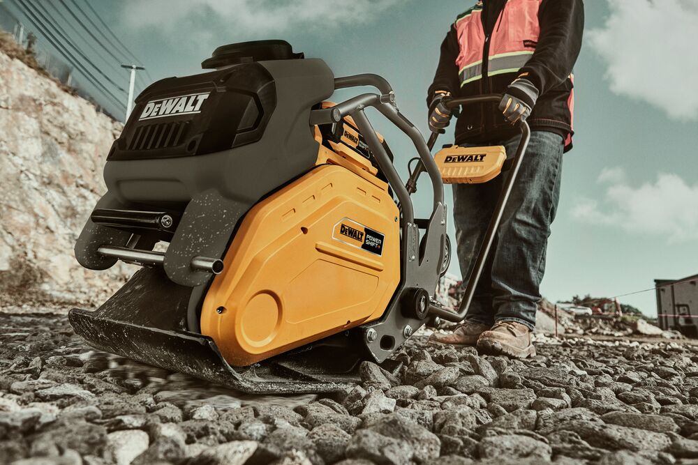 Man running plate compactor