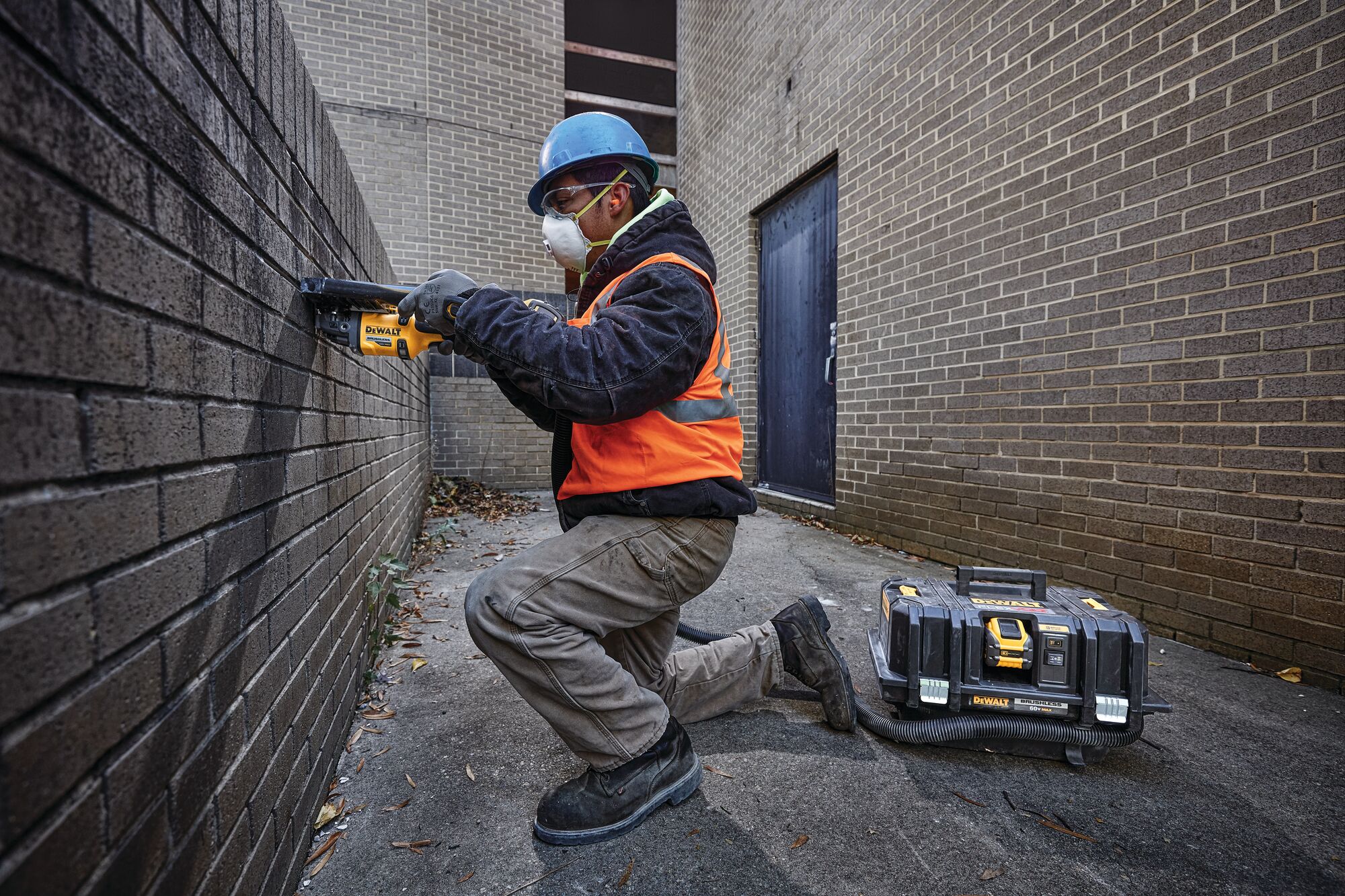 Close up of 5 to 6 inch tuckpointing and cutting shroud motor powered by a generator being used to cut at a brick wall by a worker.
