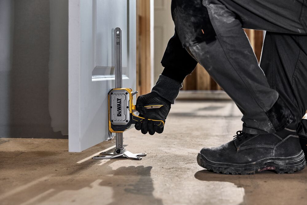 Worker lifting a door with DEWALT(R) TOUGHSERIES(TM) CONSTRUCTION JACK