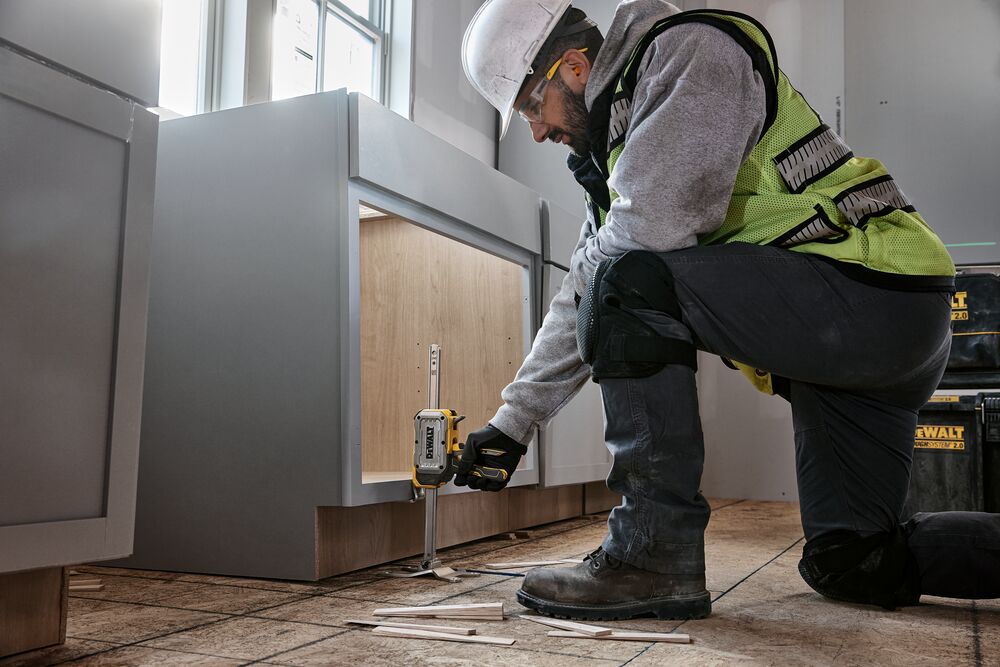 Worker lifting a cabinet with DEWALT(R) TOUGHSERIES(TM) CONSTRUCTION JACK 
