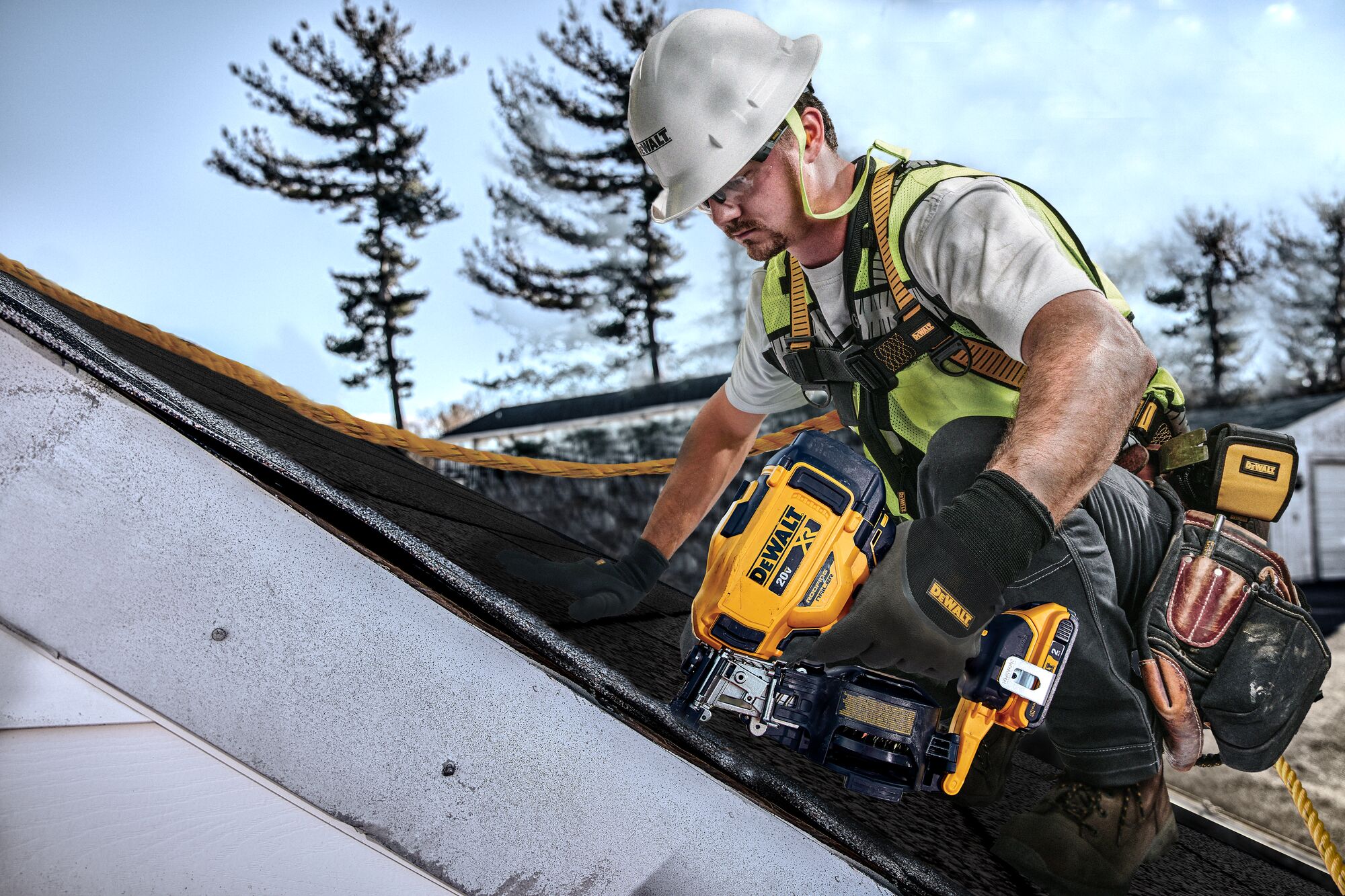 Construction worker on roof with safety harness working. 