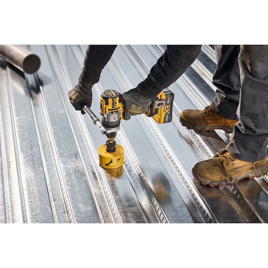 20V MAX* XR® Brushless Cordless 1/2 in. Hammer Drill drilling 4" hole into steel deck using DEWALT hole saw