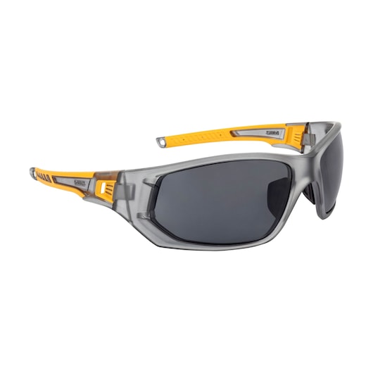 Right angle of DEWALT DPG112 full frame safety glass with gray frame, smoke lens, and yellow overmolded temples.