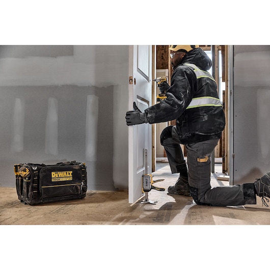 Worker leveling a door with DEWALT(R) TOUGHSERIES(TM) CONSTRUCTION JACK 