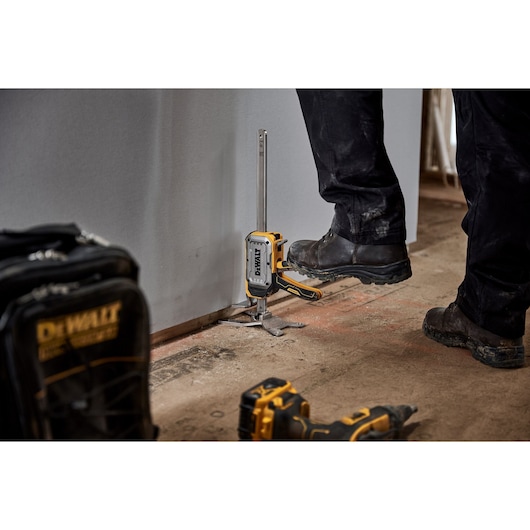 Worker lifting drywall with DEWALT(R) TOUGHSERIES(TM) CONSTRUCTION JACK step to lift feature