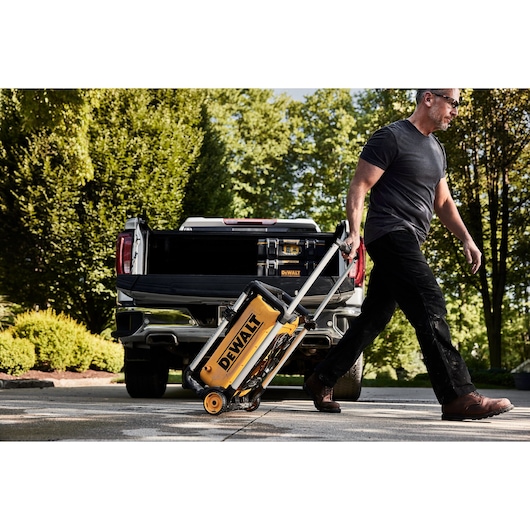 DEWALT 15 Amp Electric Cold Water Pressure Washer being pulled by a man in front of a truck parked in a driveway. 
